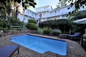 a large blue swimming pool in front of a building at Brenton Beach House in Brenton-on-Sea