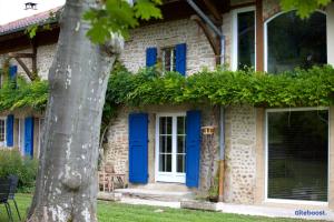 ein Haus mit blauen Türen und einem Baum in der Unterkunft La Demeure de Camille 