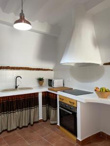 cocina con fregadero y fogones horno superior en La Rosita alojamiento rural, en Hinojares