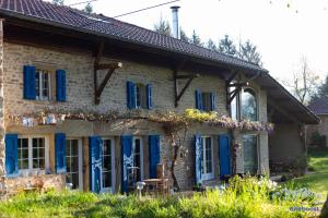 Casa de piedra con puertas y ventanas azules en La Demeure de Camille, 