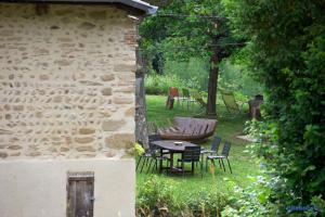 ein Steingebäude mit Stühlen und einem Tisch im Hof in der Unterkunft La Demeure de Camille 