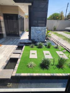 a garden with grass and plants in front of a building at The Residence Villa in Musina