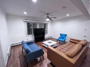 ウェストバリーにあるModern and spacious villa close to NYC/Brooklyn/Queens/Garden Cityのリビングルーム(ソファ、青い椅子2脚付)