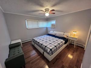 1 dormitorio con 1 cama y ventilador de techo en Modern and spacious villa close to NYC/Brooklyn/Queens/Garden City, en Westbury