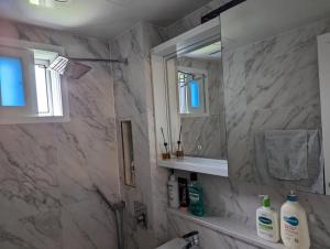La salle de bains est pourvue d'un lavabo et d'un miroir. dans l'établissement Stunning Luxury Apartment, à Séoul