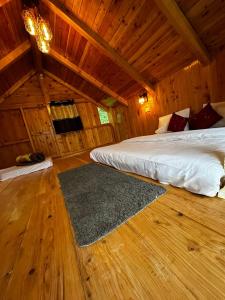 una camera con 2 letti in una cabina di legno di ThePahadians Food & Stay a Jibhi