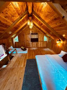 a large room with two beds in a wooden attic at ThePahadians Food & Stay in Jibhi