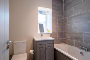 a bathroom with a tub and a sink and a toilet at Cosy Northumbrian Cottage in Barrasford
