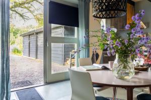 een eetkamer met een tafel met een vaas met bloemen bij Voel je thuis in Zwolle