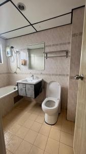 uma casa de banho com um WC, um lavatório e um espelho. em Condo D'Savoy @ Famosa, Malacca em Malaca