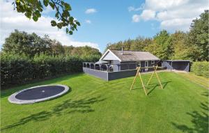 a backyard with a trampoline in the grass at 2 Bedroom Nice Home In Sydals in Neder Lysabild