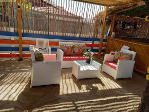 a patio with white chairs and a couch and a table at La Isla Bonita in Punta Rucia