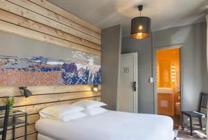 een slaapkamer met een wit bed en een schilderij aan de muur bij Hôtel de Russie in Le Mont-Dore