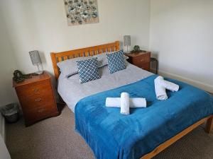 - une chambre avec un lit avec deux croix dans l'établissement Snug - Meadhan Apartment, à Helensburgh