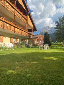 un edificio con un tavolo da picnic nell'erba di Appartamenti Césa Col De Pin a Canazei