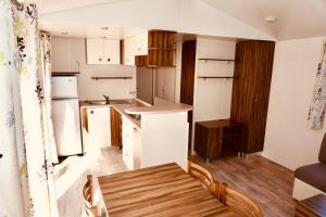 a kitchen with white appliances and a wooden floor at BR22 Emplacement confort aux Pierres Couchées 4 étoiles in Saint-Brevin-les-Pins