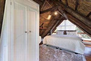 a bedroom with a white bed in a attic at La Ferme Guest Farm in Franschhoek