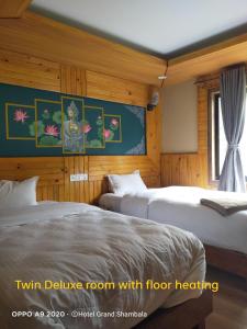 ein Hotelzimmer mit 2 Betten und einem Fenster in der Unterkunft Hotel Grand Shambala in Muktināth