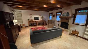 uma sala de estar com um sofá e uma lareira em Mida & Lino' s House casa rustica em Solagna