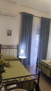 a bedroom with a green bed and blue curtains at Anthea in Naples