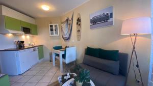 een keuken en een woonkamer met een bank en een tafel bij Appartement dans résidence les jardins de Neptune saint cyprien plage,piscine, jeux enfants in Saint-Cyprien