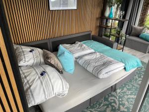 a bed with pillows on it in a room at Tinyhouse mit Alpen- Stadt- und Poolblick , WLAN in Passau