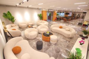eine Lobby mit weißen Sofas, Tischen und Stühlen in der Unterkunft Elite Port Hotel in Arnavutköy