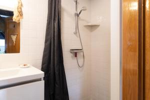 a shower with a black shower curtain in a bathroom at Voel je thuis in Zwolle