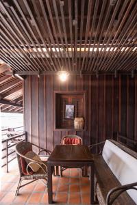 a table and chairs in a room with wooden walls at Ancient Luangprabang Hotel in Luang Prabang
