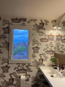 ein Bad mit einem Fenster und einem Waschbecken in der Unterkunft Romantic attic room with panoramic view in Bologna