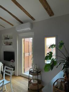 sala de estar con TV, mesa y planta en Romantic attic room with panoramic view en Bolonia