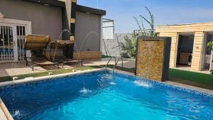 a swimming pool in front of a house at merana charlet in Ash Shāghūr