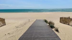 a wooden boardwalk on a beach near the ocean at Studio Chaleureux au Cap d’Agde in Cap d'Agde