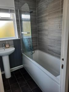 a bathroom with a bath tub and a sink at Taunton Central in Taunton