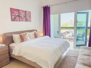 1 dormitorio con 1 cama grande y balcón en Dreams & Themes Ansam Yas Island 108A3, en Abu Dabi