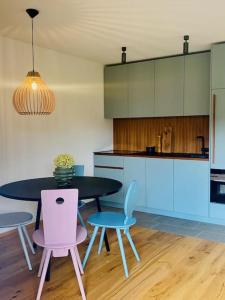 a kitchen with a table and two chairs and a kitchen with blue cabinets at Traumhafte Ferienwohnung in historischem Brandmanngut in Marquartstein