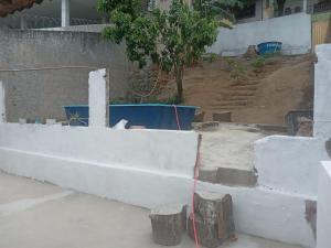 a concrete retaining wall with a red hose at Hostel Leonardo in Vitória