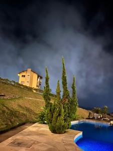 une maison au sommet d'une colline à côté d'une piscine dans l'établissement Apbananeiras - Condomínio Sonhos da Serra, à Bananeiras