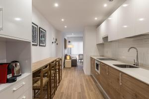 a kitchen with white counters and a wooden counter top at BNBHolder Best I Madrid Rio in Madrid