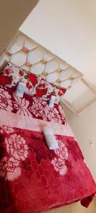 a bed with a red and white quilt on it at maison Halima in Ifrane