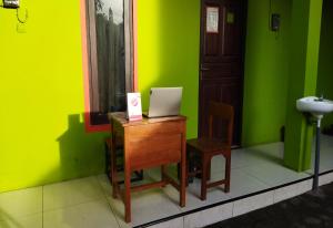Camera verde con scrivania e computer portatile. di Wisma Almadina Syariah a Jepara