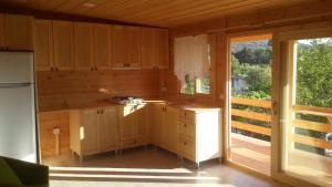 a kitchen with wooden cabinets and a large window at Paradise Garden Apartments in Gümüşlük