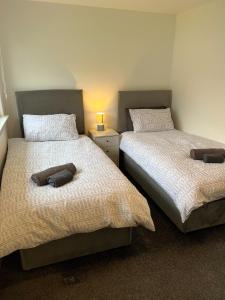 two beds sitting next to each other in a bedroom at The Wee Hoose Rhu in Rhu
