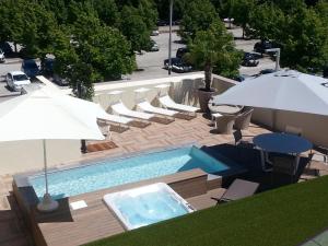an overhead view of a swimming pool with chairs and umbrellas at "La Conchiglia d' Oro" HOTEL & SPA in Vicenza