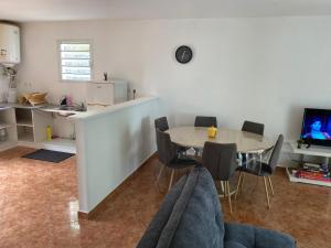 sala de estar con mesa y cocina en Charmante villa créole, en Grande Ravine