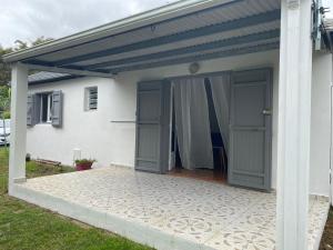 un garage avec deux portes sur le côté d'une maison dans l'établissement Charmante villa créole, à Grande Ravine