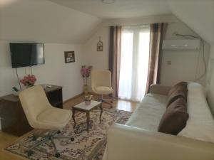 a living room with a couch and two chairs and a television at Apartman Vera in Srbobran