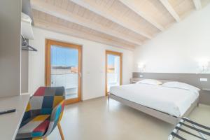 1 dormitorio con 1 cama, escritorio y sillas en Nuova -Luxury Rooms & Apartment-, en Olbia