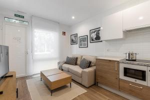 a kitchen and a living room with a couch at BNBHolder Best II Madrid Rio in Madrid