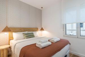 a bedroom with a bed with towels on it at BNBHolder Best II Madrid Rio in Madrid